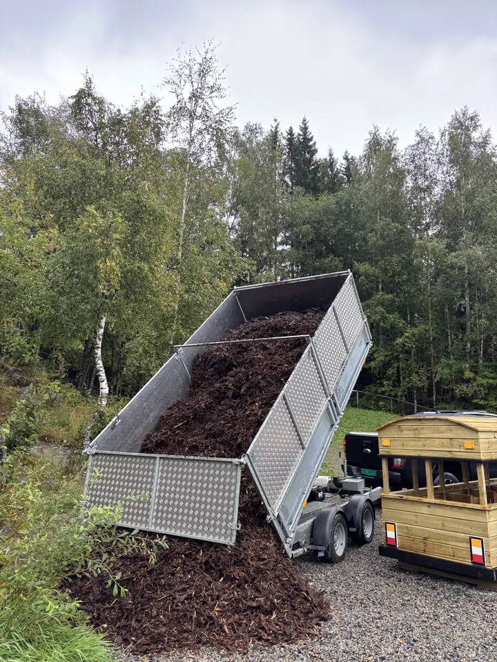 Tilhenger tipper bark ved en lekeplass