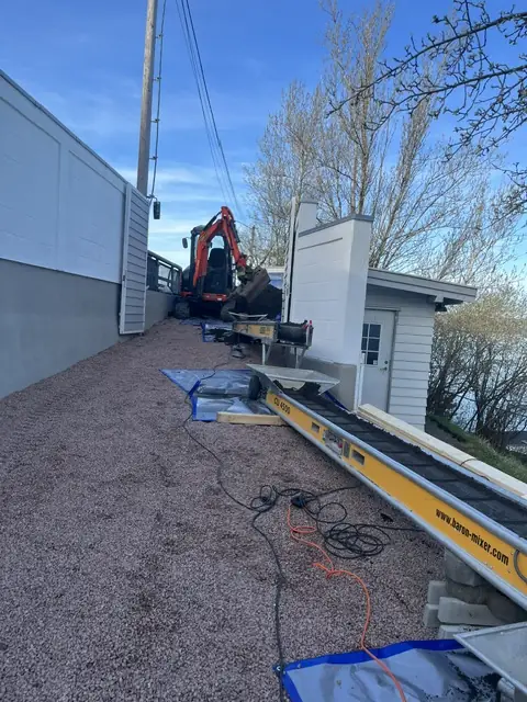 Grus avrettes langs en husvegg